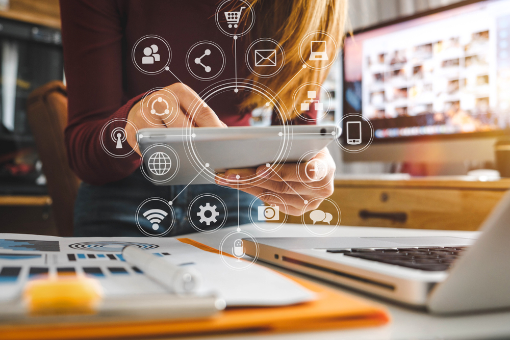 Person using tablet with digital network icons.