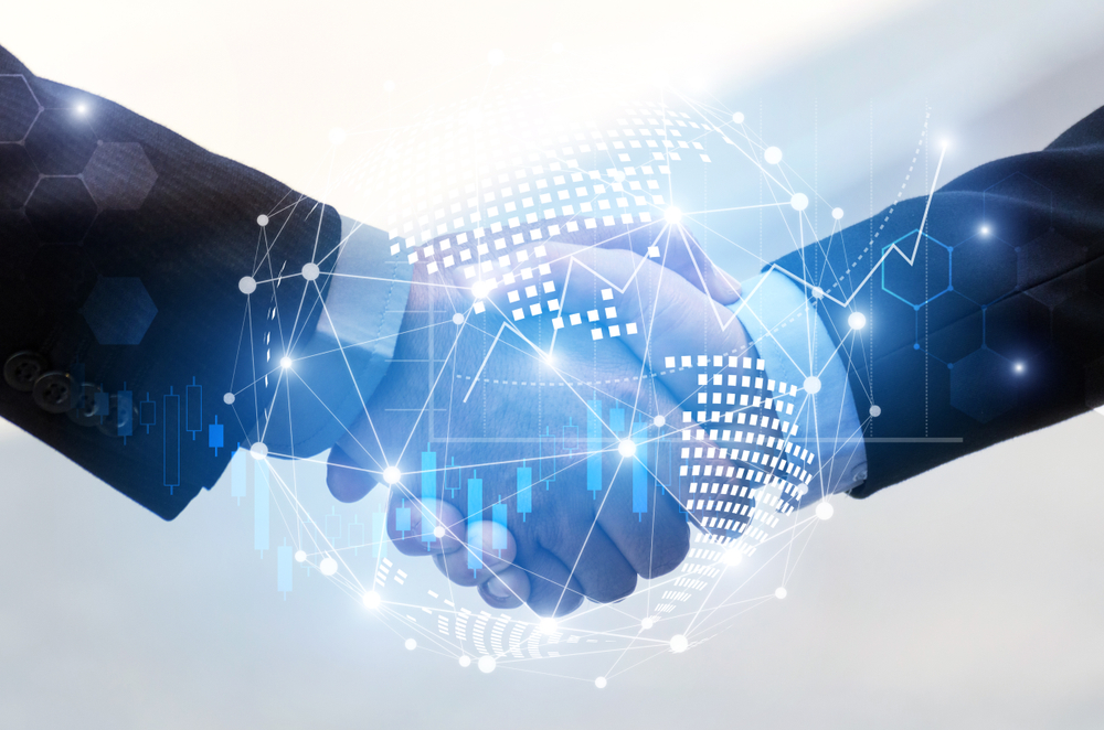Business handshake with digital technology overlay.